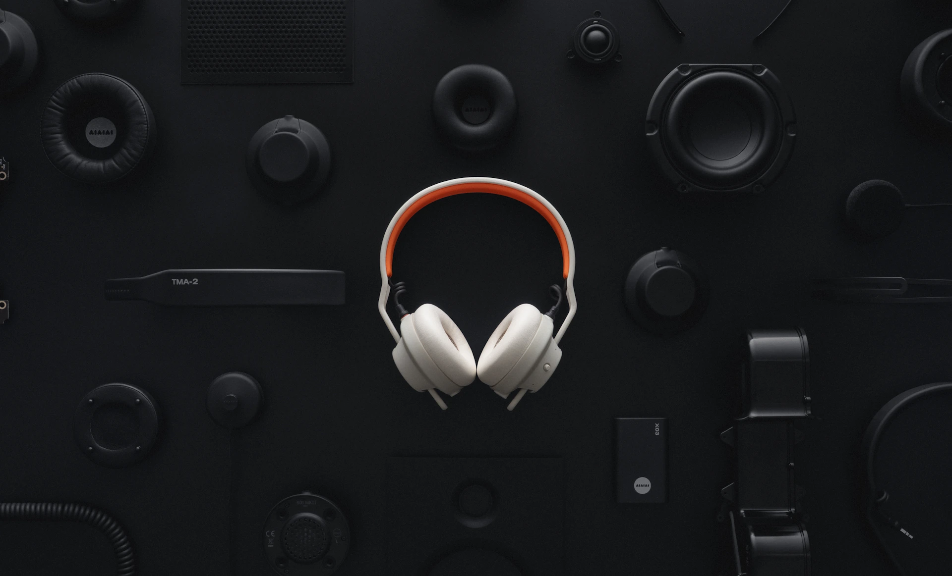 AIAIAI TMA-2 DJ Wireless branco ao centro, cercado pelas peças avulsas da linha TMA-2 sobre fundo preto