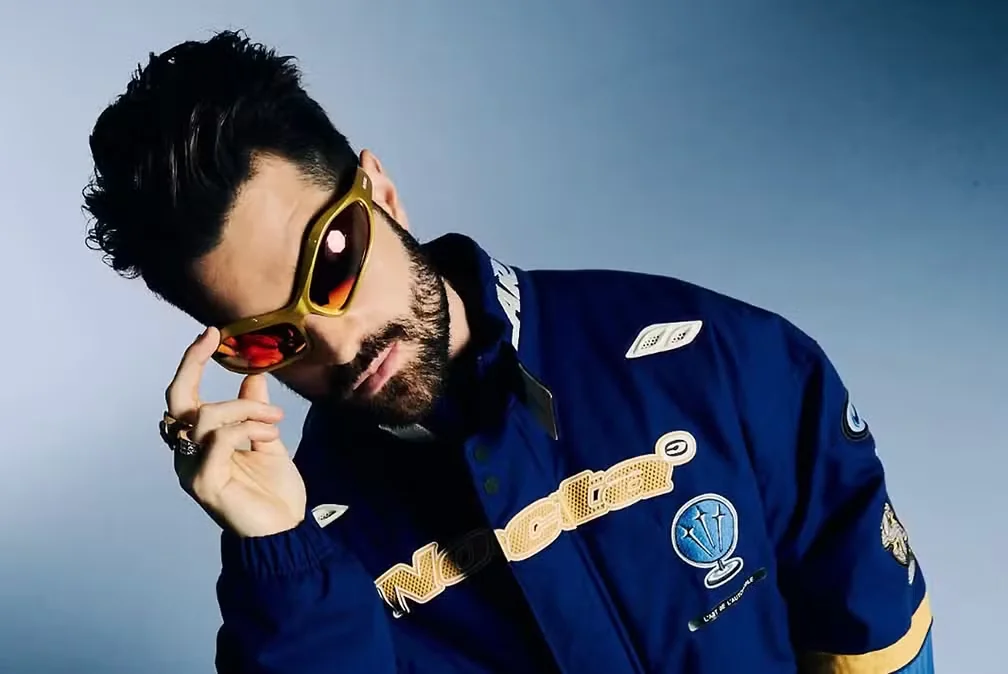 Alok com a camisa Rave The World em cima do palco de um festival