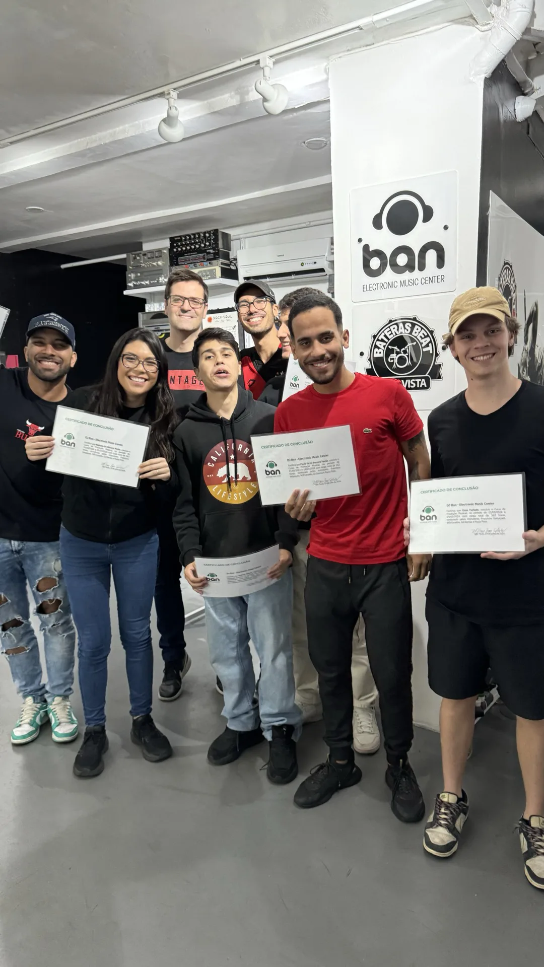 Turma de alunos formados no curso de Produção Musical DJ Ban EMC São Paulo segurando certificados de conclusão