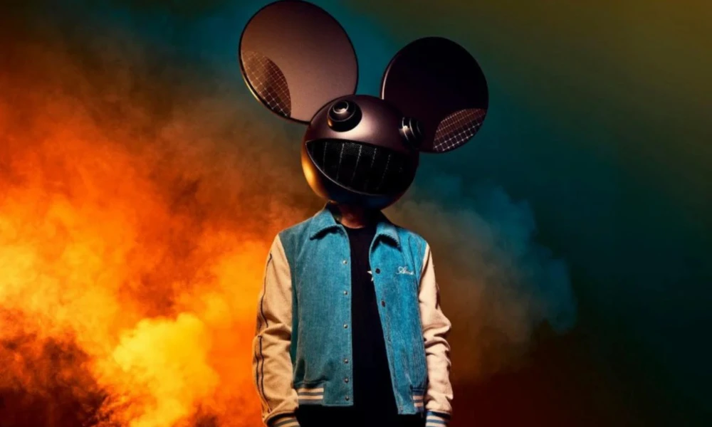 Foto de divulgação de deadmau5 com o capacete de rato iluminado, jaqueta jeans de mangas claras, na frente de fumaça laranja e azul