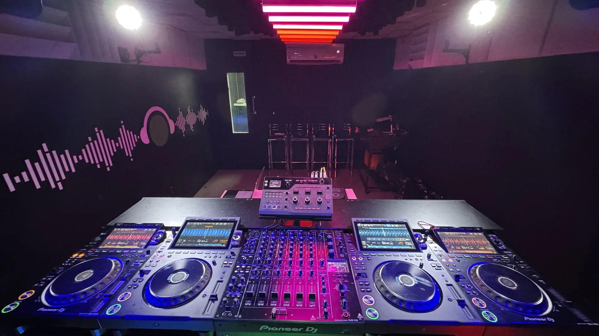 Cabine com quatro CDJs e mixer Pioneer DJ ligados, no estúdio 1 da DJ Ban EMC