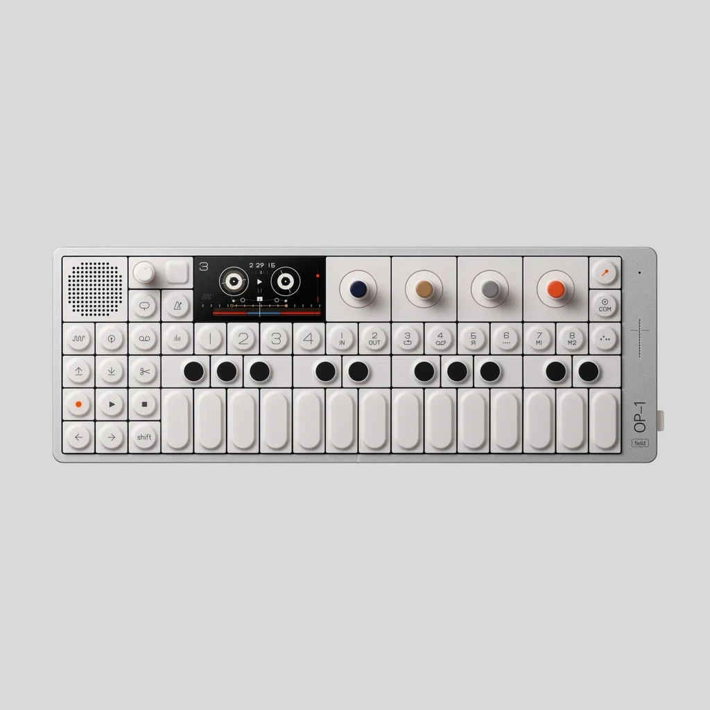 Foto oficial do sintetizador OP-1 field, da Teenage Engineering, visto de cima sobre fundo cinza claro, com tela colorida, quatro knobs e teclas brancas