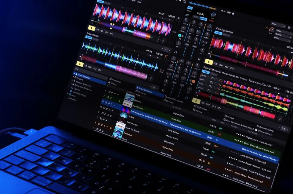 Tela do Traktor Pro rodando num laptop, com quatro decks, formas de onda e a biblioteca de faixas aberta