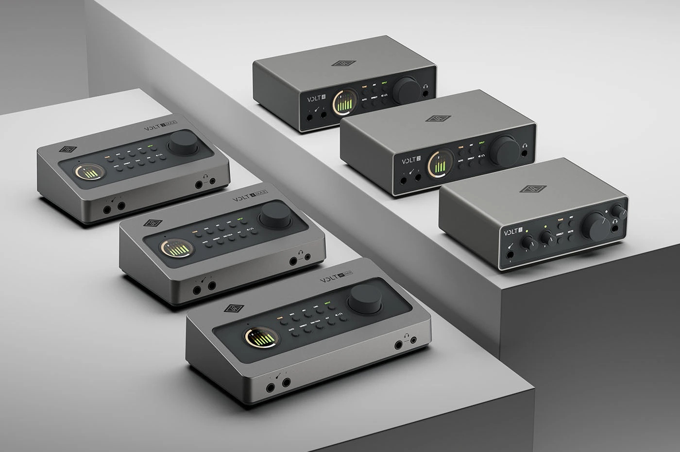 Foto oficial de divulgação das seis interfaces Universal Audio da nova linha Volt, três Volt Max inclinadas à esquerda e três Volt Gen 2 à direita, em cinza grafite sobre blocos cinza claro
